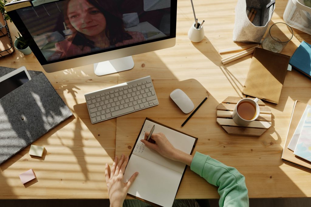 a desk with a computer and a notebook