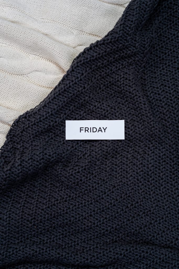 a piece of paper with Friday written on it laid on black and white material